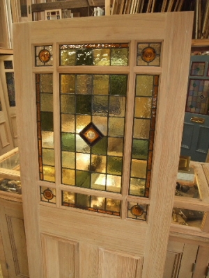 A lovely stained glass internal door incorporating pastel green and amber stained glass with amber rondels